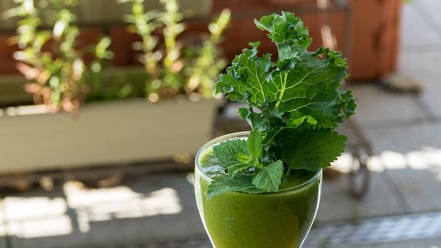 Fresh made glass of kale juice garnished with kale leaves.