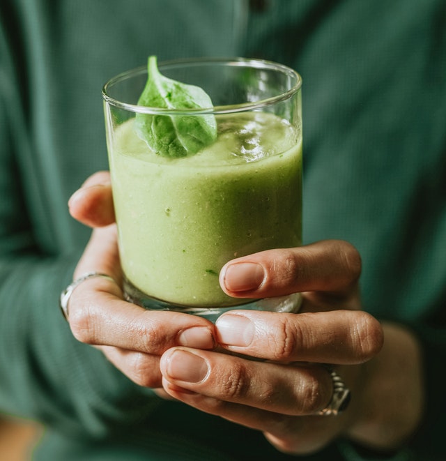 Guy holding a glass of Brussels Sprouts juice